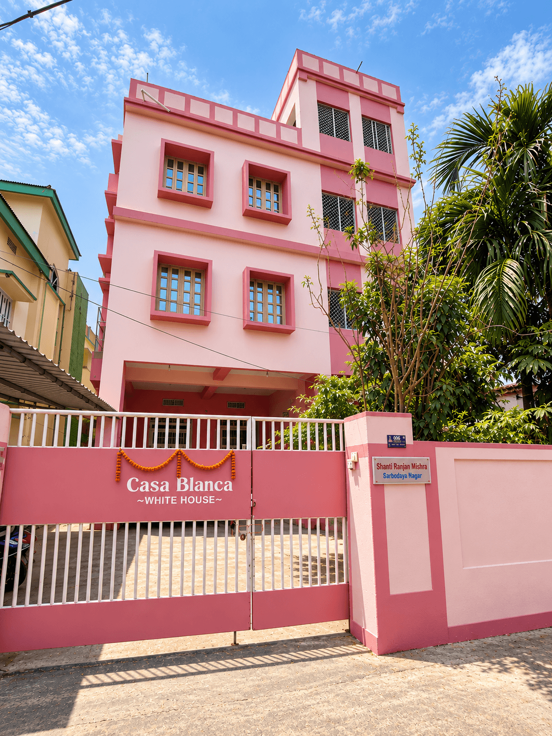 The pink facade of Casa Blanca Homestay in Puri